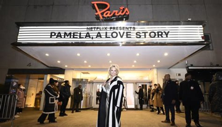 Pamela Anderson Paired a Cowl Neck Satin Gown with a Draped Wool Coat